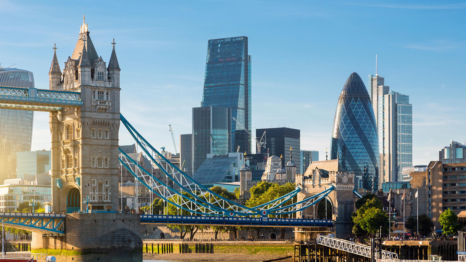 a bridge over water with a city in the background