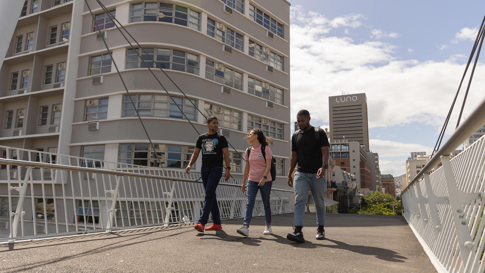 a group of people walking on a bridge