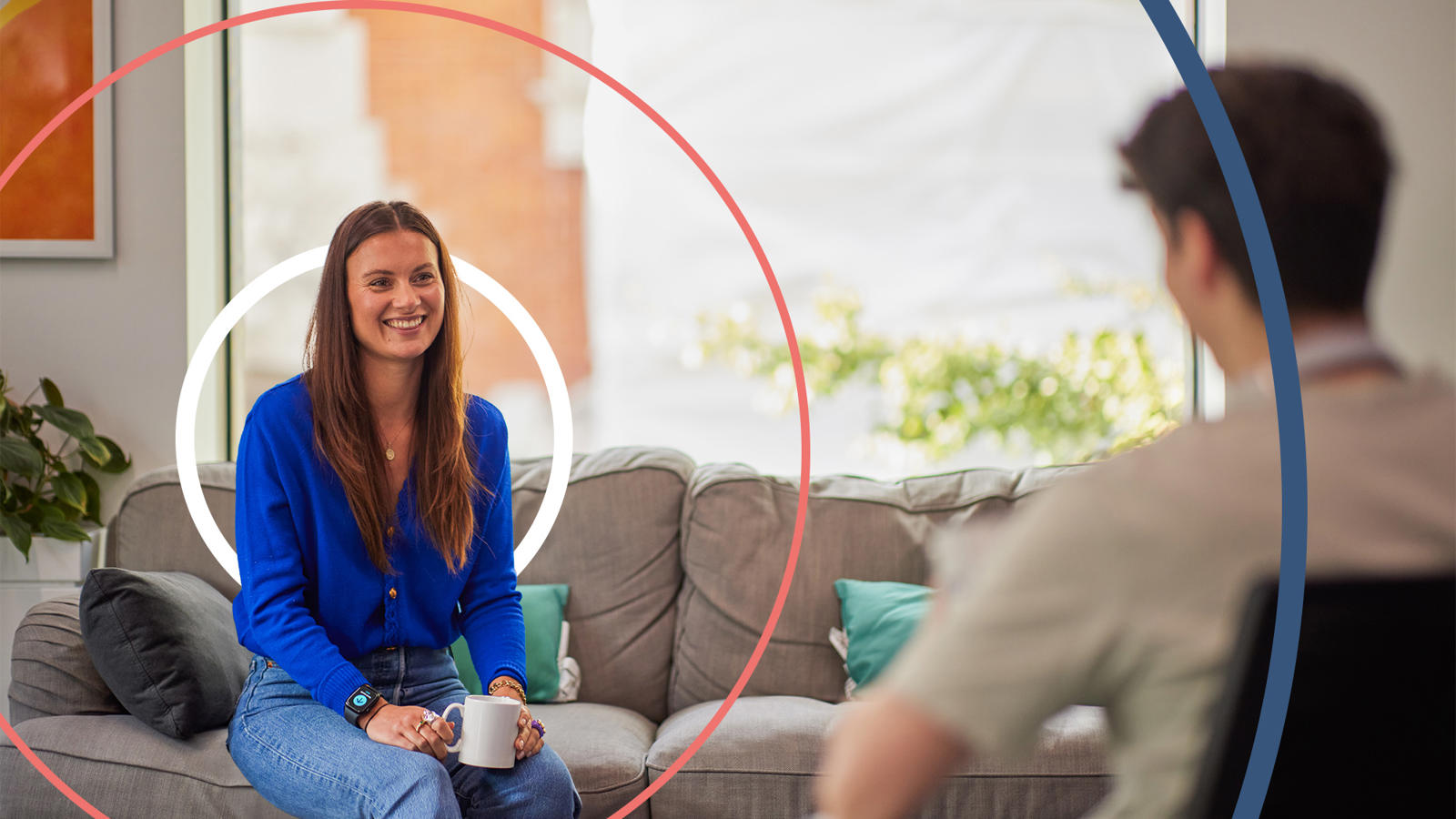 a woman sitting on a couch holding a mug