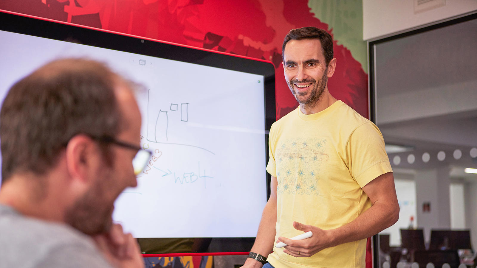 a man standing in front of a whiteboard